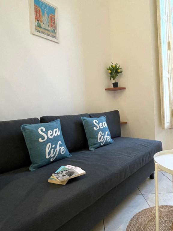 d'un canapé bleu avec deux oreillers qui disent la vie en mer dans l'établissement Michelangelo Résidence, à Nice