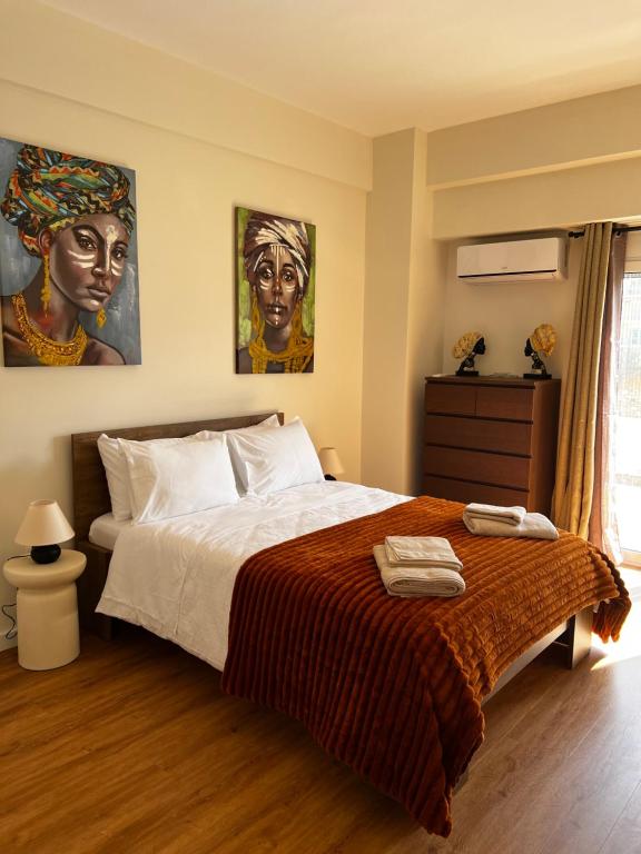 a bedroom with a bed with two paintings on the wall at La Maison in Patra