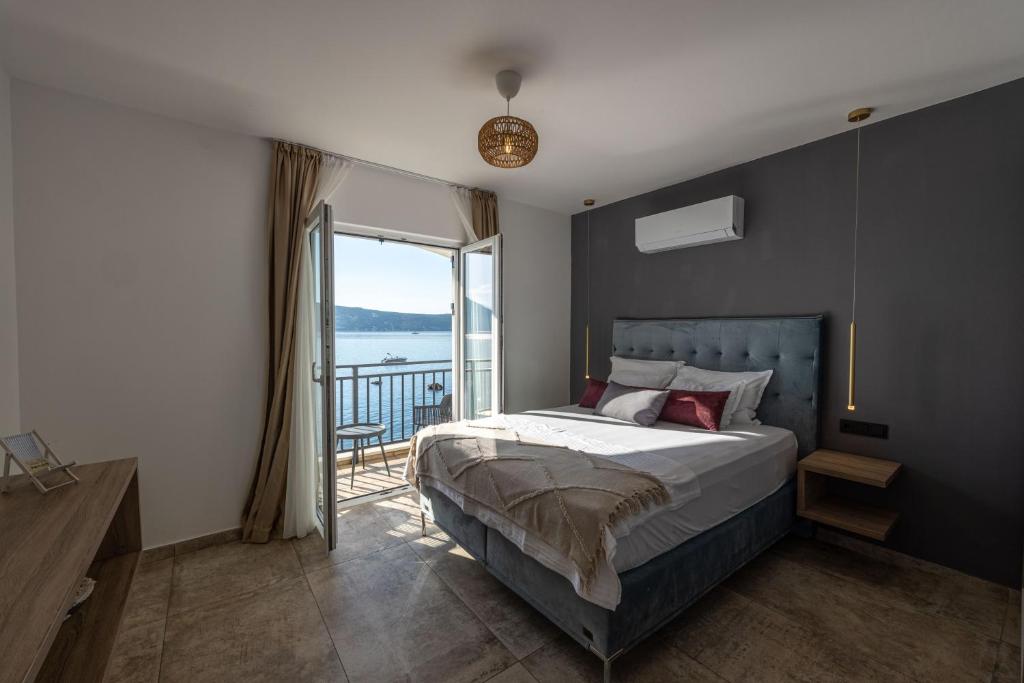 una camera con un grande letto e un balcone di Boka Bay Residences a Herceg-Novi