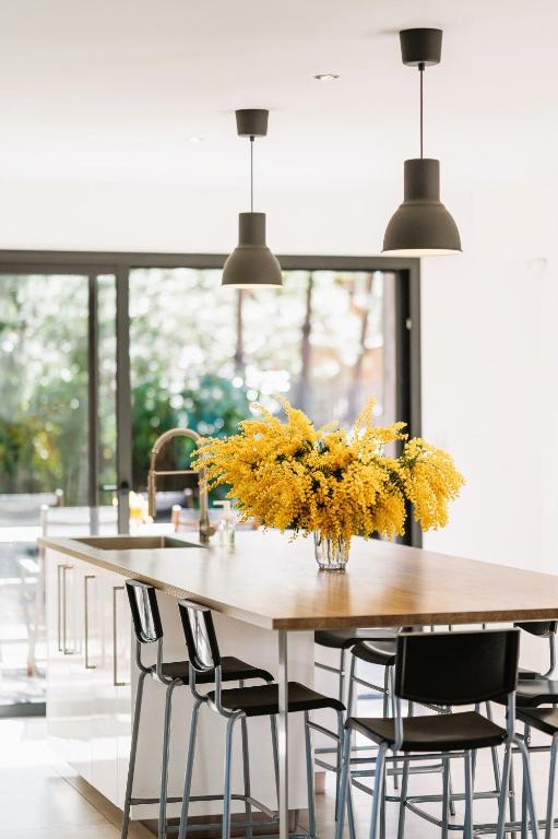 une cuisine avec une table et un vase de fleurs jaunes dans l'établissement Villa cork contis 1, à Lit-et-Mixe