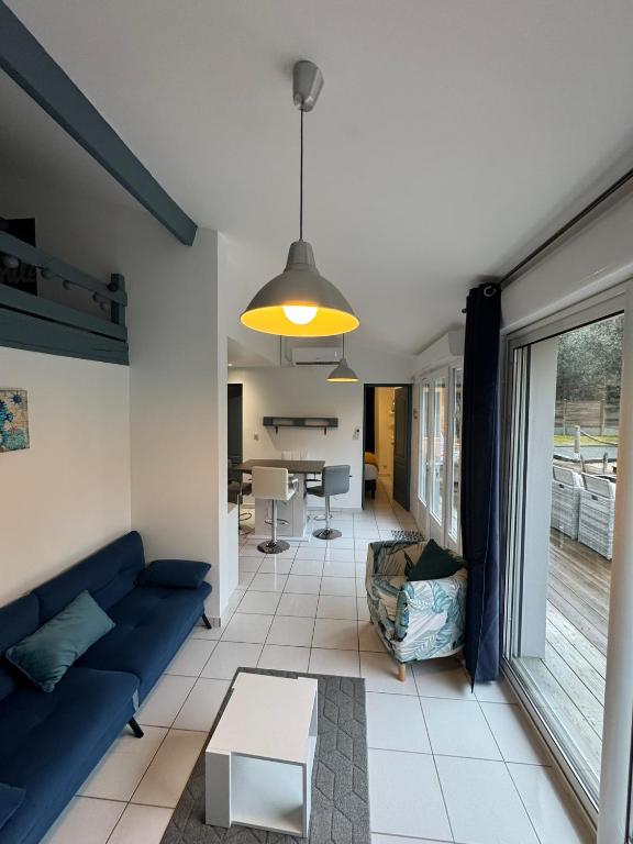 un salon avec un canapé bleu et une table dans l'établissement Dépendance avec piscine et spa partagés - plage 130 m, à Soulac-sur-Mer