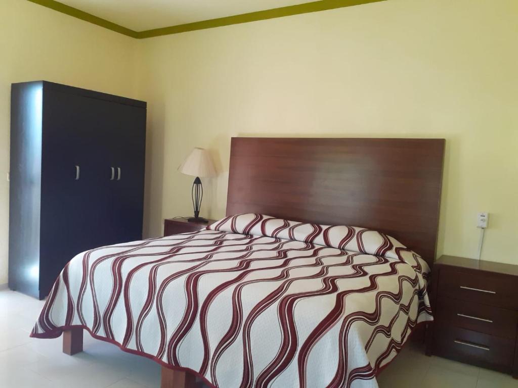 a bedroom with a large bed with a wooden headboard at Casa Quetzal in Peñita de Jaltemba