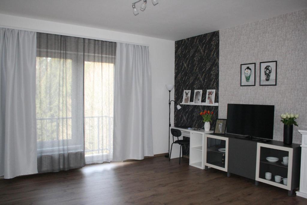 a living room with a television and a desk at WITH LOVE Marienbad Ap Garden 2 in Mariánské Lázně