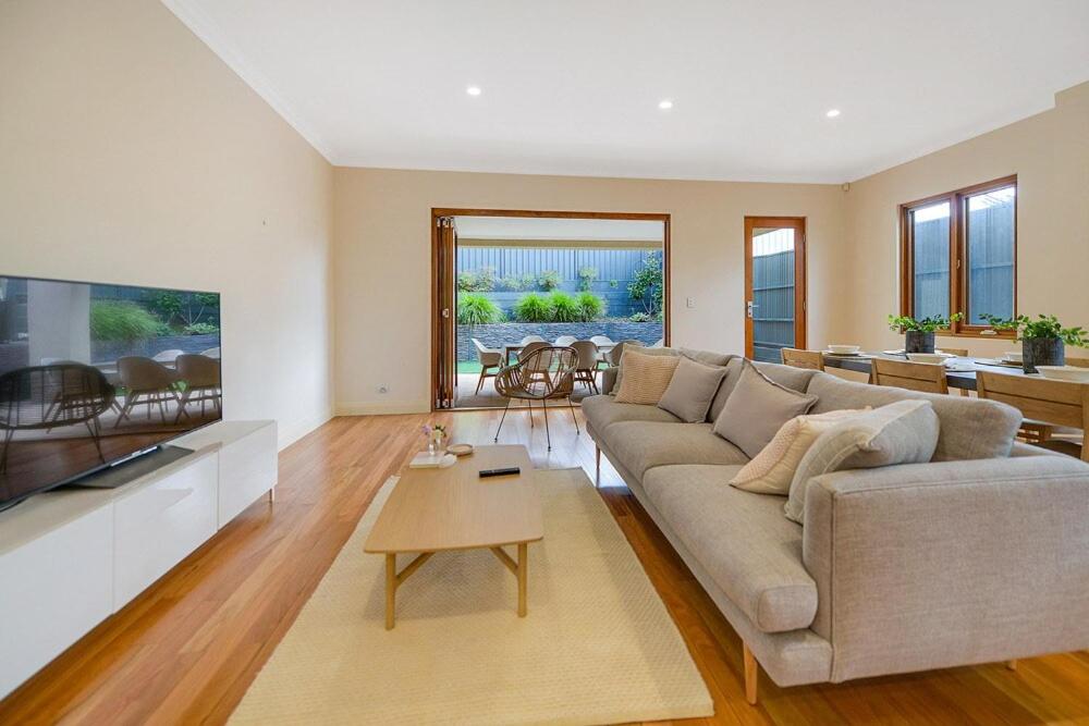 a living room with a couch and a table at Aria House - Henley Beach - Family Holiday Beachside BBQ in Henley Beach