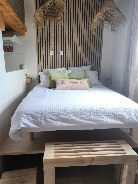 - un lit avec un banc en bois dans une chambre dans l'établissement Le cabanon, à Taglio-Isolaccio