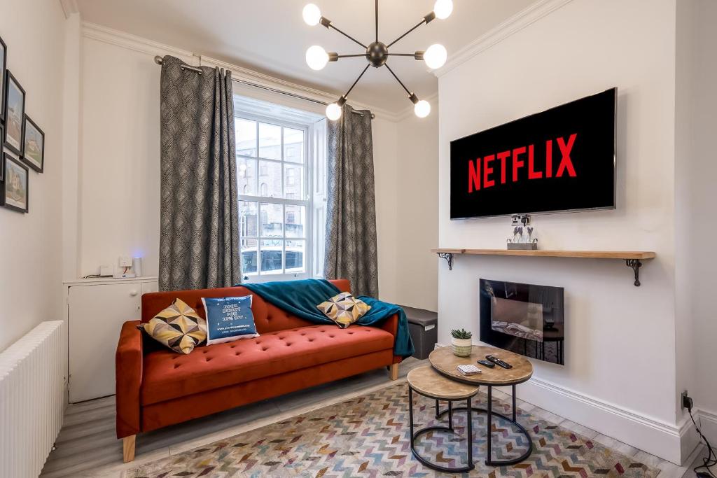 a living room with a couch and a fireplace at StayByNumbers - City Centre Victorian Townhouse in Belfast