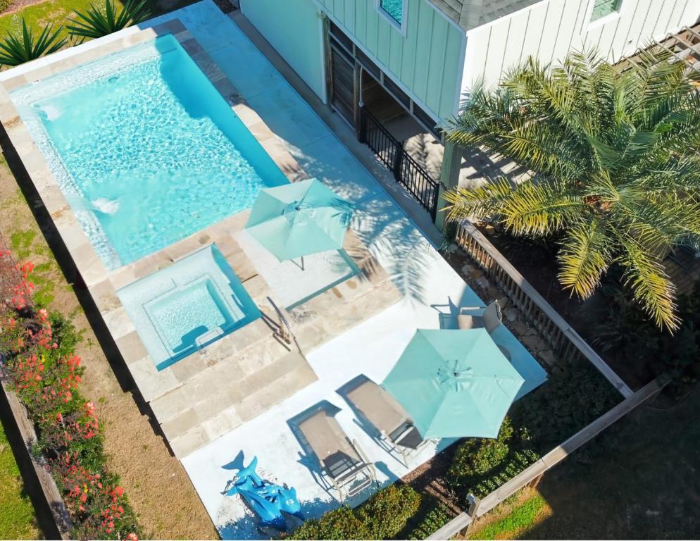 Una vista aérea de una piscina con sombrillas. en Beachside Dream, Heated Poolhot Tub, 2 King Beds, en Galveston