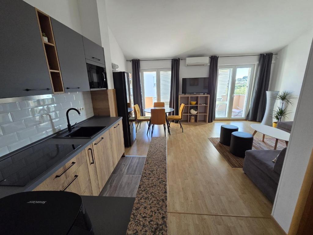kuchnia i salon z kanapą i stołem w obiekcie Apartments in Krk w Krku