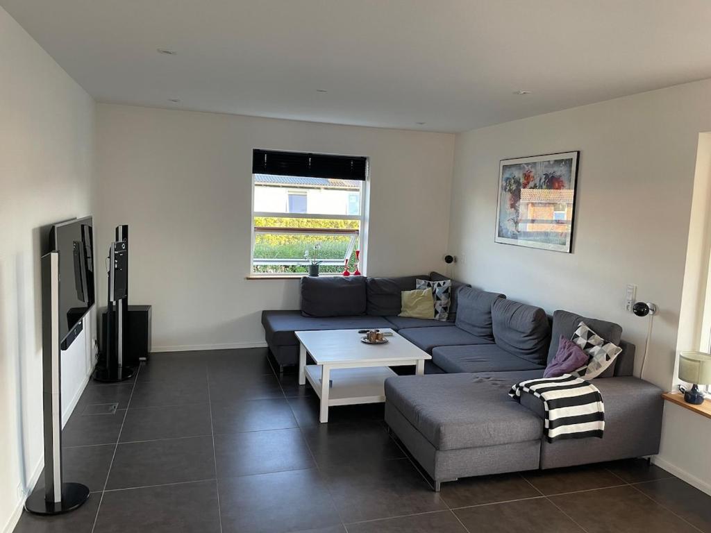 a living room with a couch and a table at Cozy house in Hjoerring close to city & nature in Hjørring
