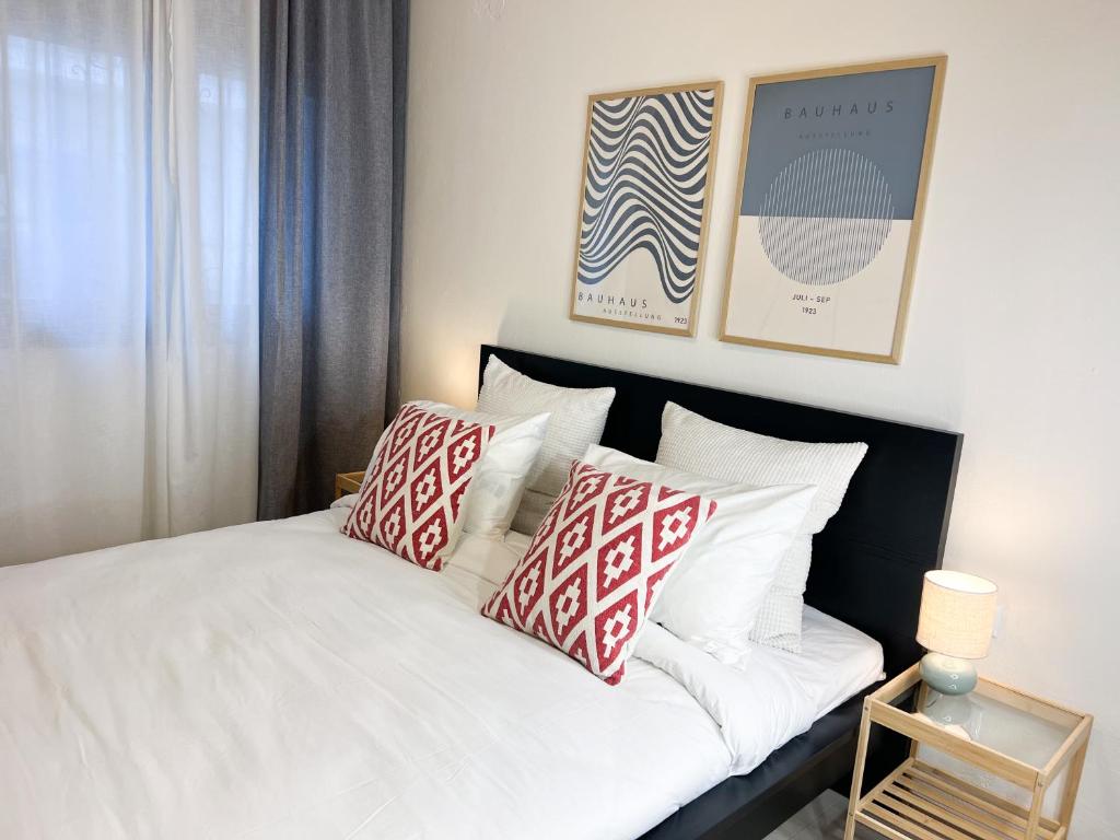 a bedroom with a bed with red and white pillows at Spacious, Near Beach & Easy Parking - by Solstad in Kavala