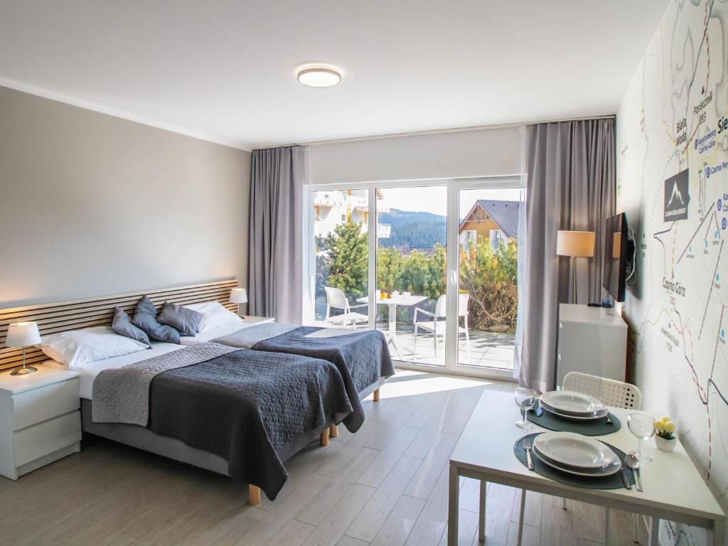 - une chambre avec 2 lits et une table dans l'établissement Apartamenty Czarna Góra Resort - Livigno 1 i 2, à Sienna