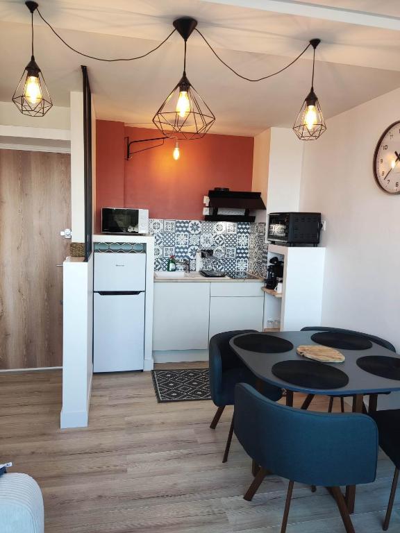 une cuisine et une salle à manger avec une table et des chaises dans l'établissement Les Lavandes, parfait pour le Thermalisme, à Balaruc-les-Bains