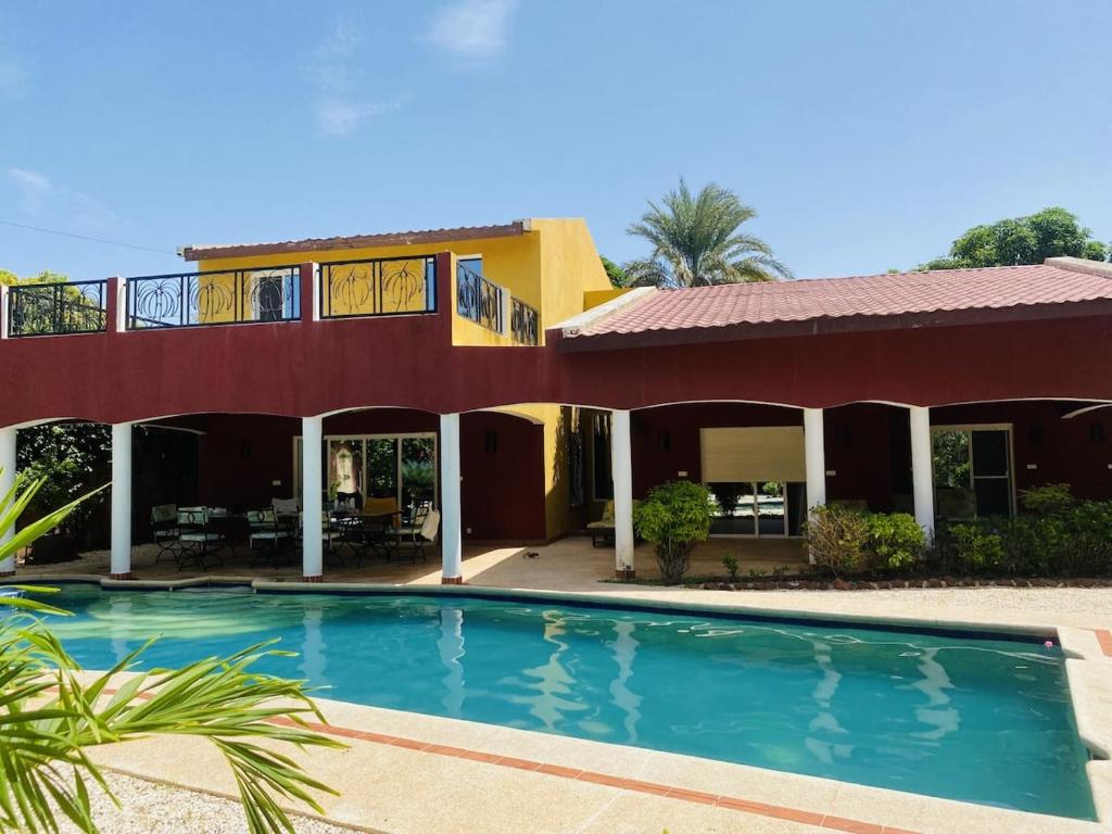 a house with a swimming pool in front of it at La Villa Tila in Warang