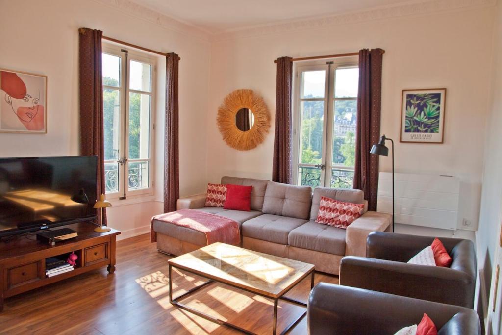un salon avec un canapé et une télévision dans l'établissement Charmant T3 ,100m2, centre ville, classé 3 étoiles, à Aix-les-Bains