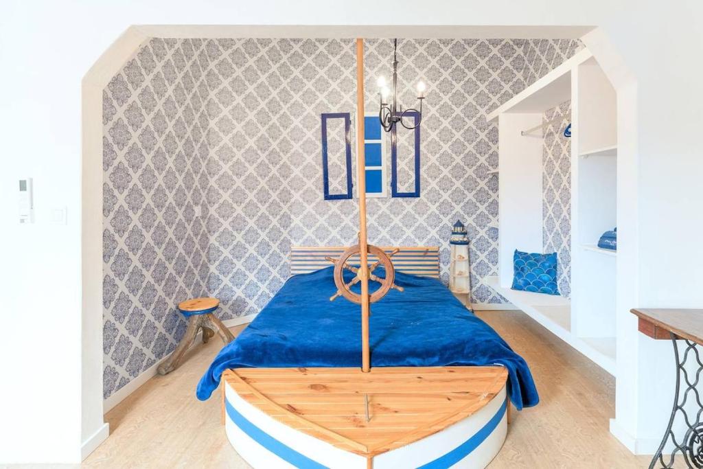 1 dormitorio con 1 cama con colcha azul en Praia de Messejana, en Messejana