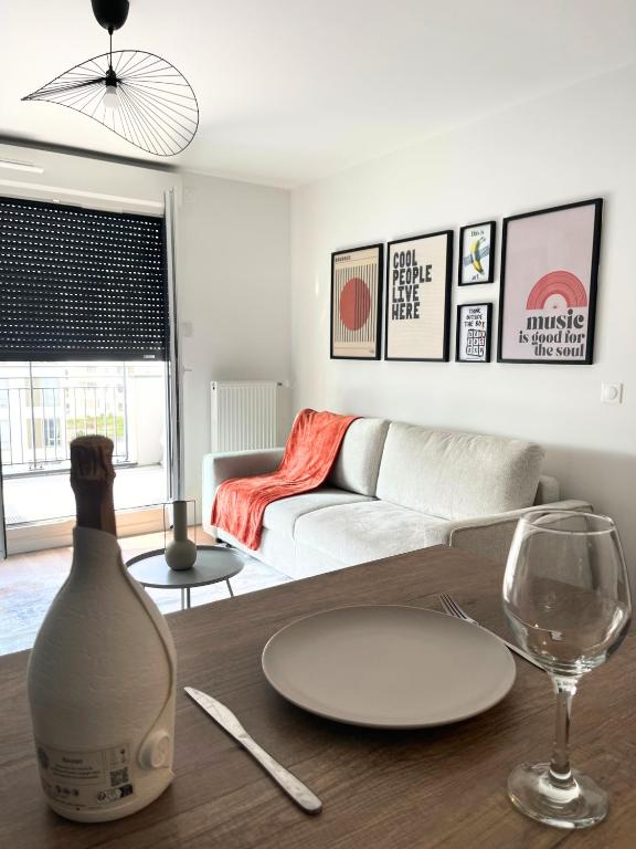 - un salon avec une table et un verre de vin dans l'établissement Dandy home F2 proche Paris et Aéroport Orly, à Thiais