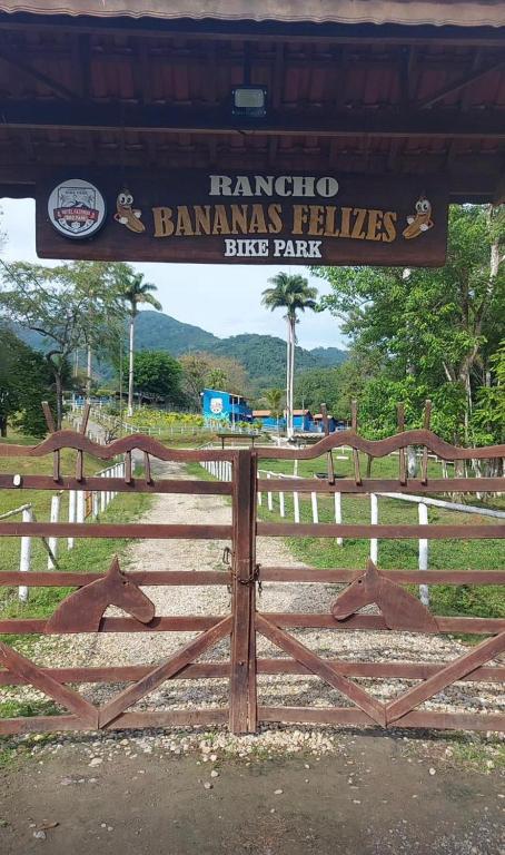 a sign on a wooden gate at a park at Pousada Rancho Bananas Felizes in Miracatu