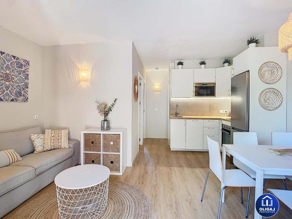 una sala de estar con un sofá y una mesa en Can Alfredo, Apartamento Cala en Bosch con piscina, terraza y jardín privado, en Cala'n Bosch