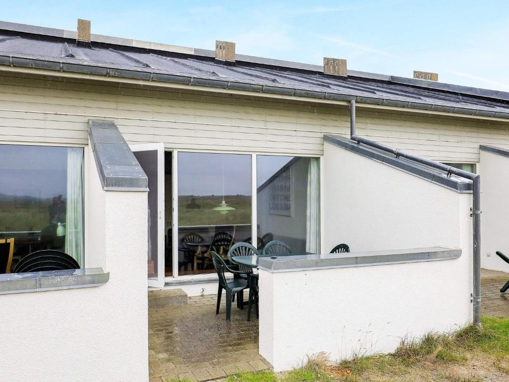 a white house with a table and chairs and windows at 6 person holiday home in Brovst in Brovst
