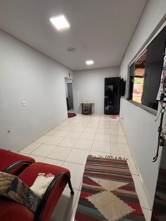 a living room with a red couch and a large window at Casa ampla com vista pra mata in Chapada dos Guimarães