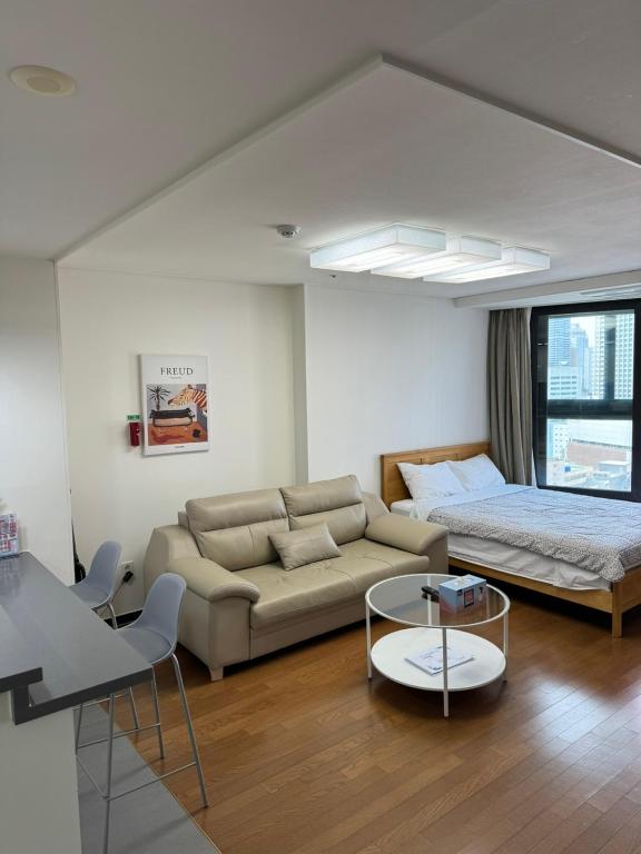 a living room with a couch and a bed at Haeundae Beach Stay Hotel in Busan
