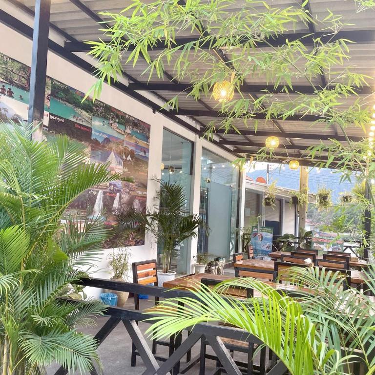 a restaurant with tables and potted plants at VangVieng Smile guesthouse in Vang Vieng