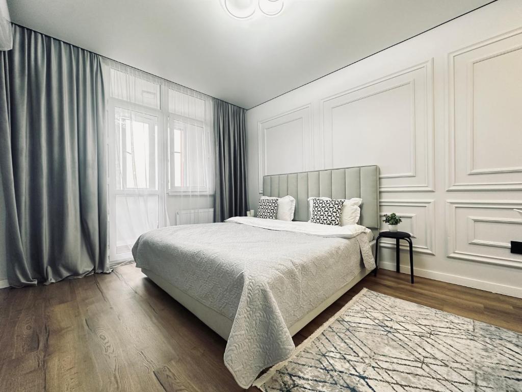 a bedroom with a bed and a large window at Alatau city 1 room in Almaty
