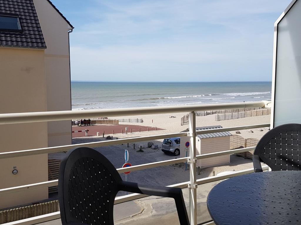 un balcon avec une table et des chaises et une vue sur la plage dans l'établissement Appartement moderne à 2 min de la plage, vue mer, animaux admis - FR-1-482-153, à Fort-Mahon-Plage