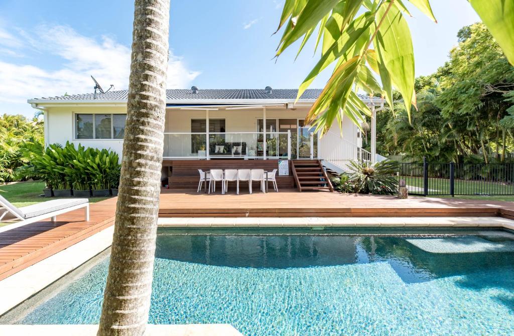 a house with a swimming pool in front of a house at Pura Vida in Noosa Heads