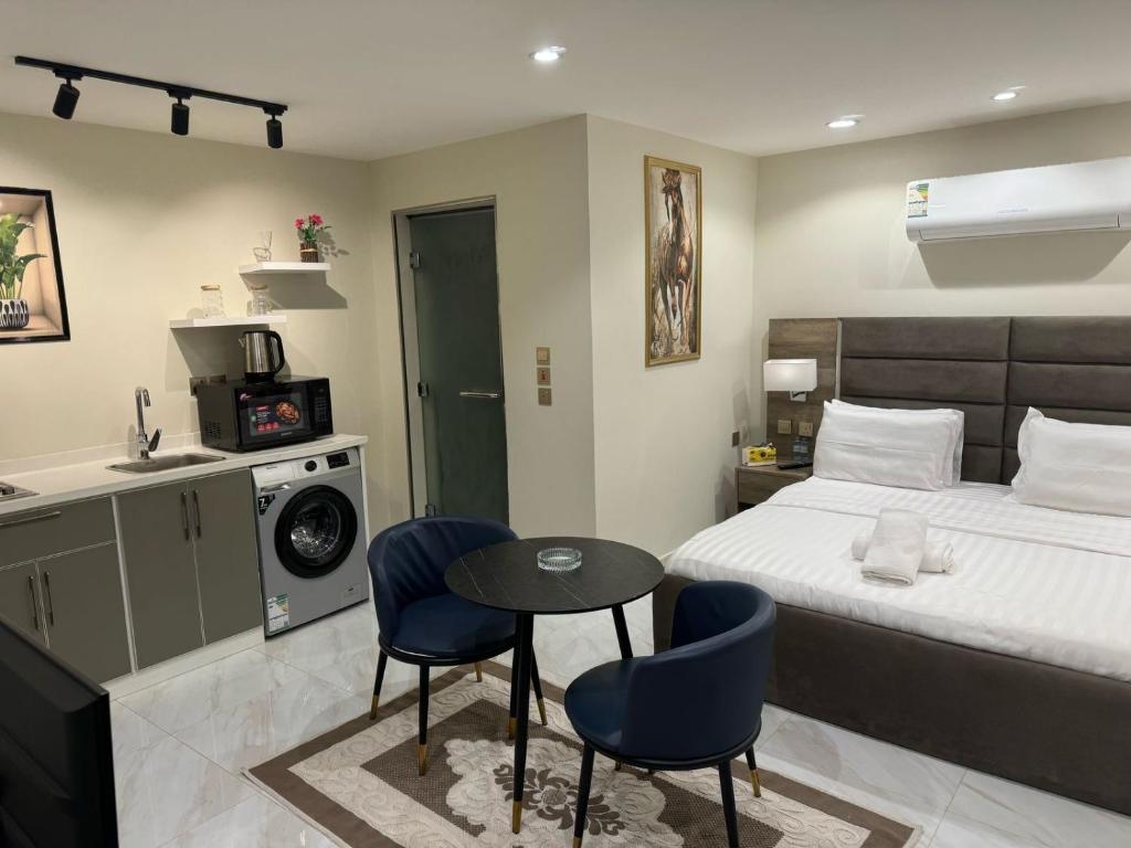 a bedroom with a bed and a table and chairs at Duba gold in Ḑubā