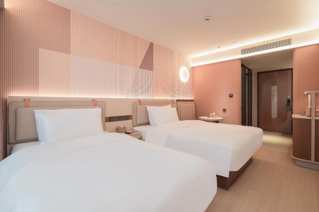 Postel nebo postele na pokoji v ubytování Orange Guangzhou Baiyun Airport Hotel