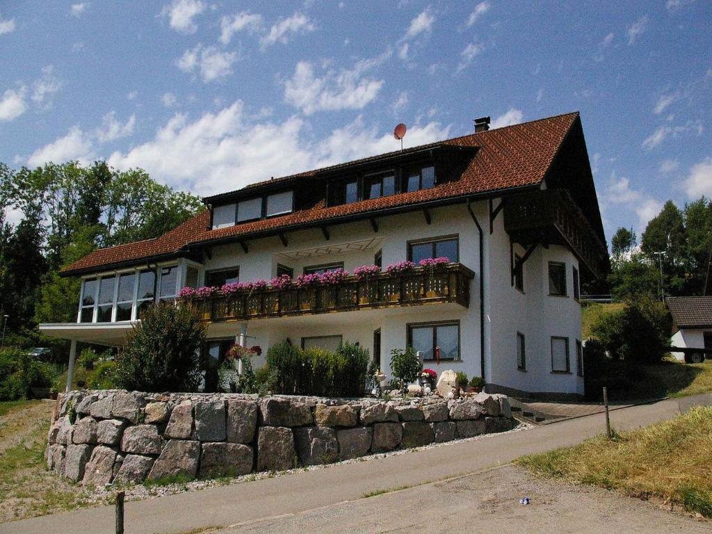 ein großes weißes Haus mit Blumen auf dem Balkon in der Unterkunft Ferienwohnung Dietsche in Dachsberg im Schwarzwald