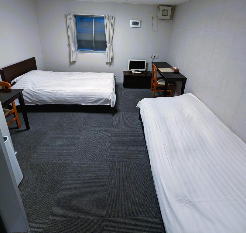 Postel nebo postele na pokoji v ubytování The Shin-Okubo International Hotel