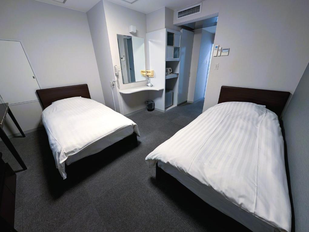 Postel nebo postele na pokoji v ubytování The Shin-Okubo International Hotel