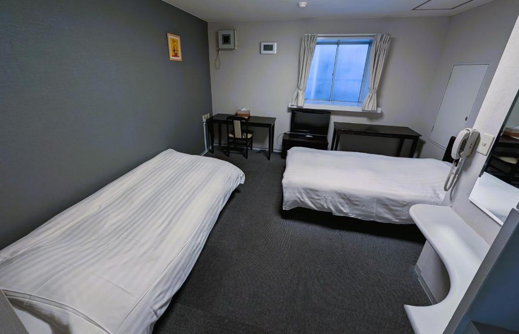 Postel nebo postele na pokoji v ubytování The Shin-Okubo International Hotel