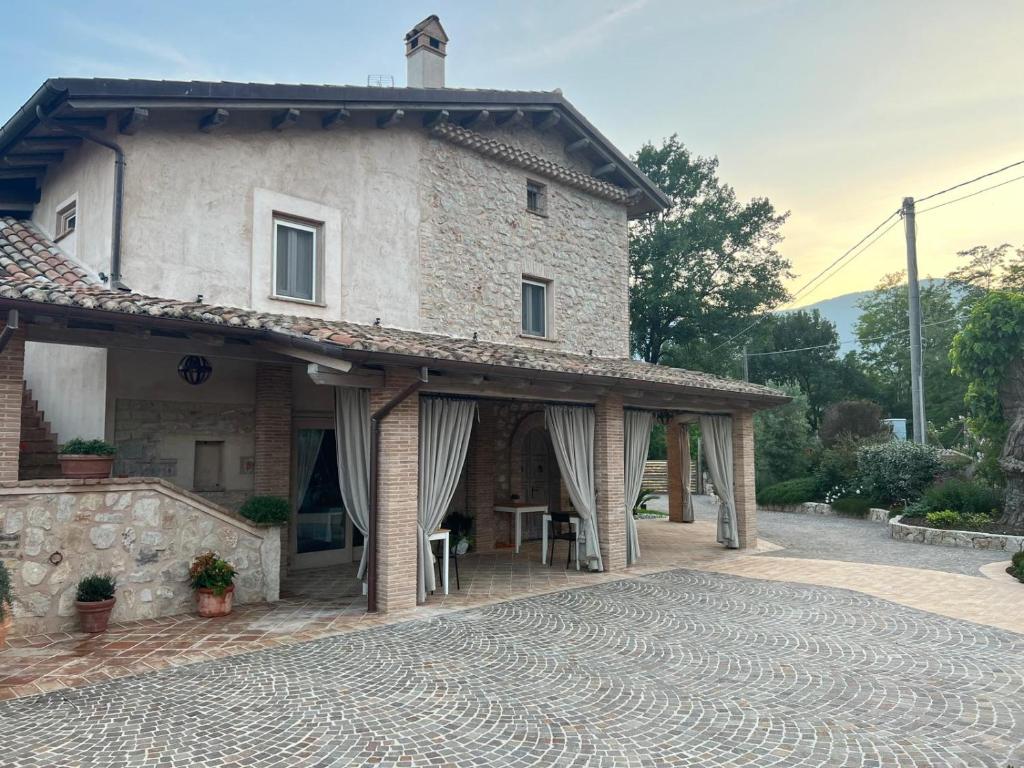 a large stone house with a patio in front of it at Agriturismo Il Casale Dei Gelsi in Monte San Biagio