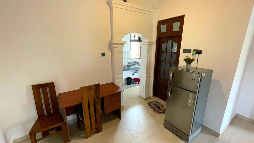 a kitchen with a refrigerator and a table and chairs at DK Korean Apartment in Unawatuna