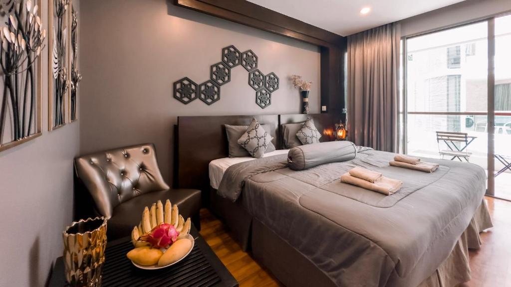 - une chambre avec un lit et une chaise avec un bol de fruits dans l'établissement Cozy studio near Bangtao Beach, à Bang Tao Beach