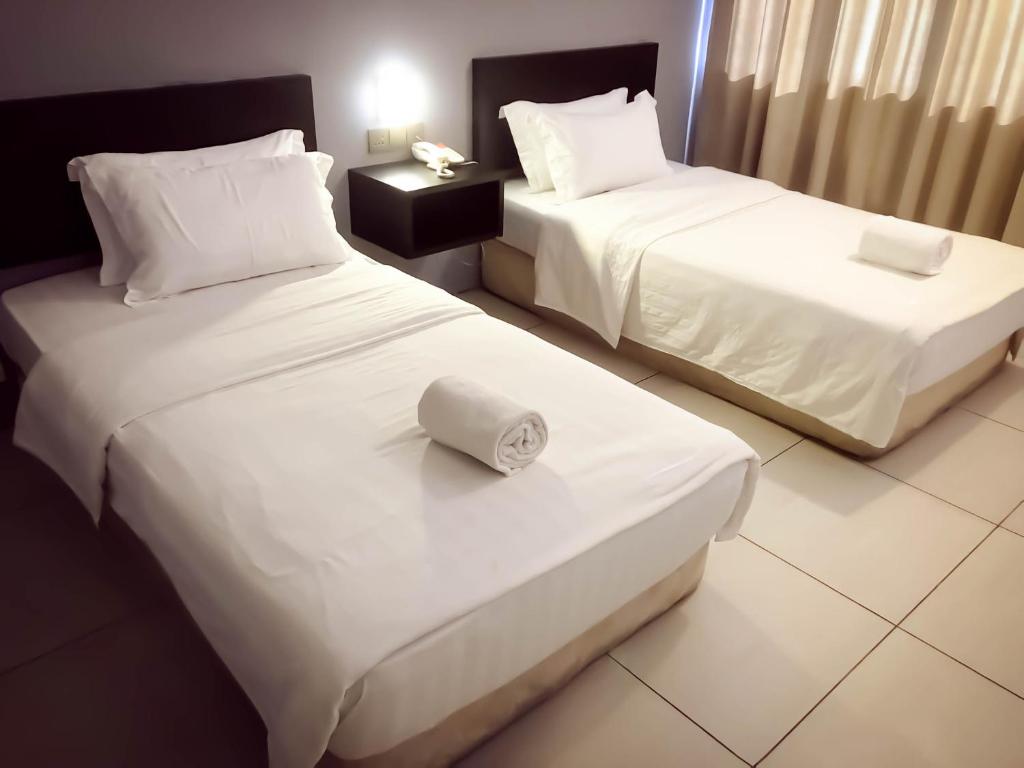 Postel nebo postele na pokoji v ubytování De Choice Hotel Tawau