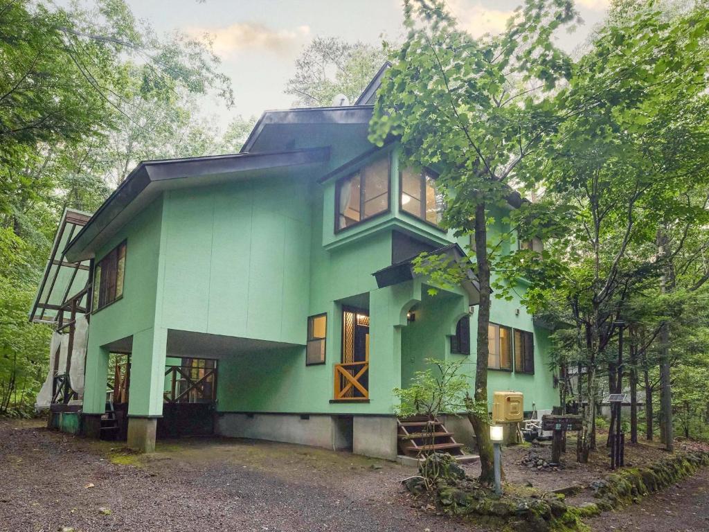 a green house with a tree in front of it at Runesu Karuizawa - Vacation STAY 78403v in Tsumagoi