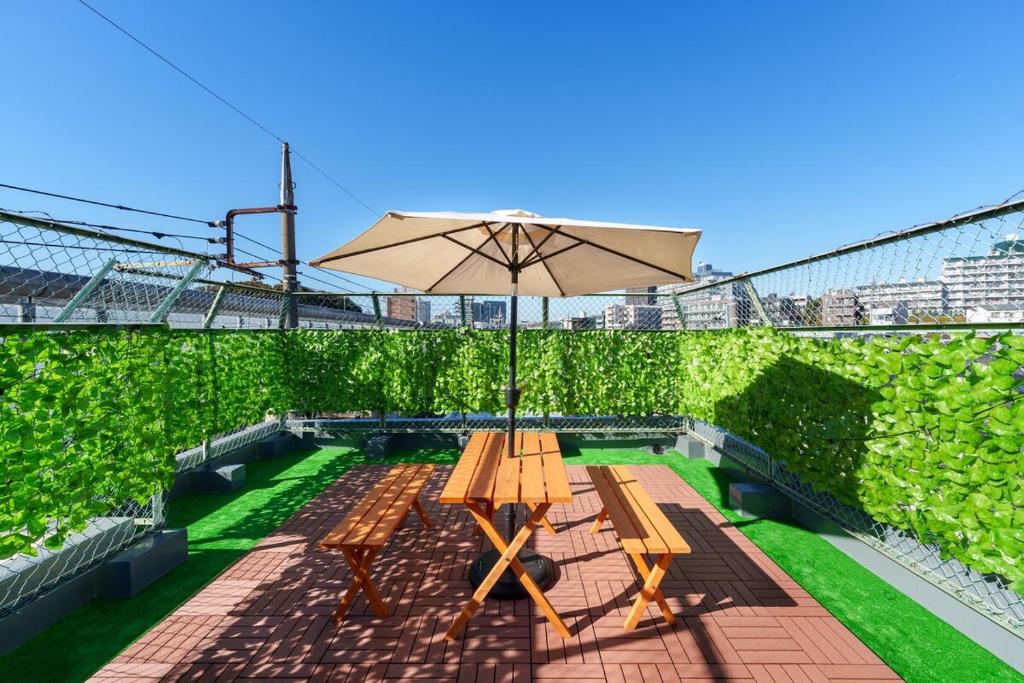 un tavolo da picnic con ombrellone su un patio di 120Tb 楓屋2F 楓屋アネックス 67m貸切 三田線志村坂上駅徒歩10分東京タワー直通キッズスペースリノベ a Tokyo