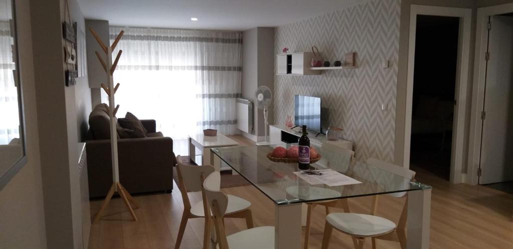 a living room with a glass table and chairs at Apartamentos Nájera in Nájera