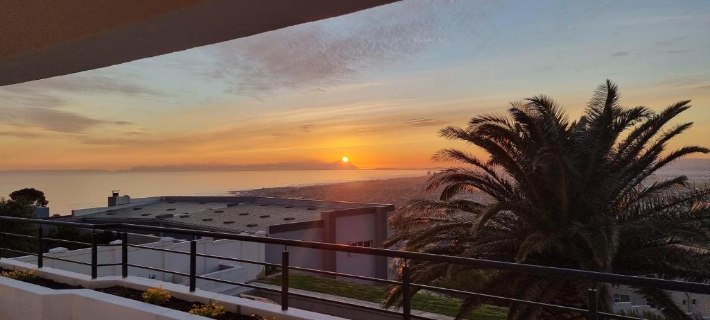 a view of a sunset from the balcony of a house at Coral Vistas Self Catering Apartments in Gordonʼs Bay