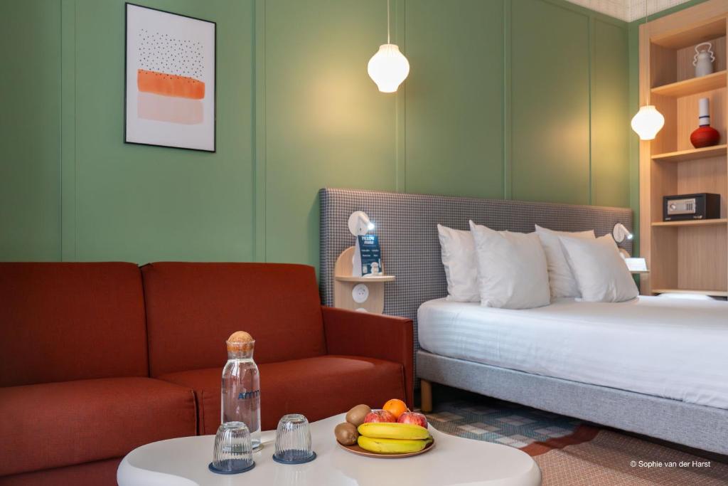 a bedroom with a bed and a couch and a table at Aparthotel AMMI Nice Lafayette in Nice