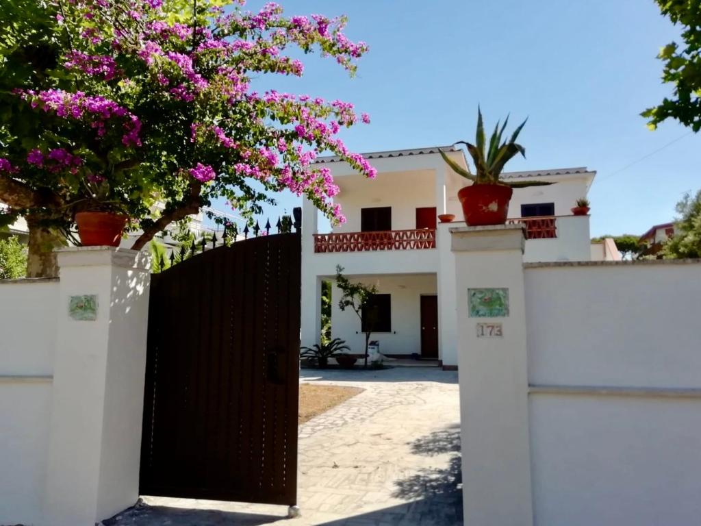 una casa con un cancello e fiori su una recinzione di The seaside villa - Anzio ad Anzio