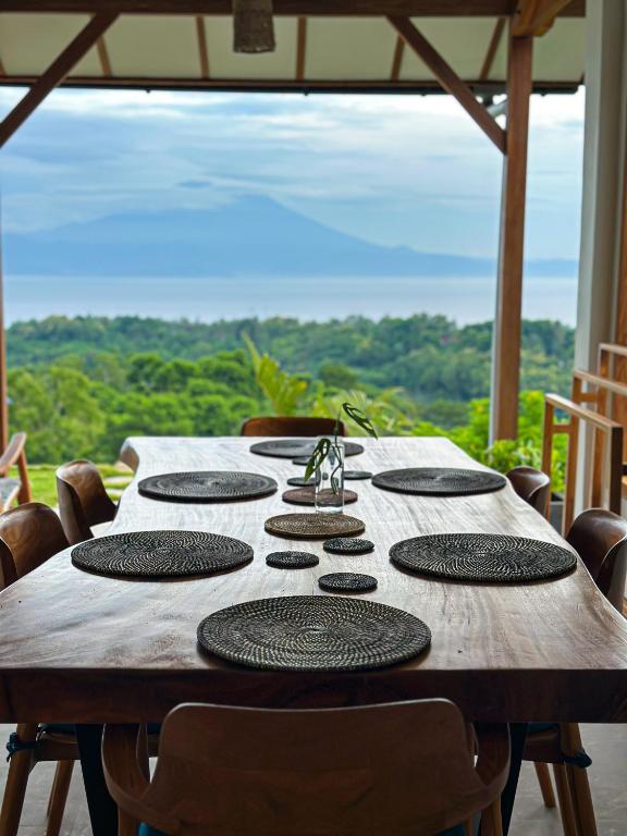 a wooden table with chairs around it with a view at Villa Treetop, 2BR with spectacular ocean view in Nusa Penida