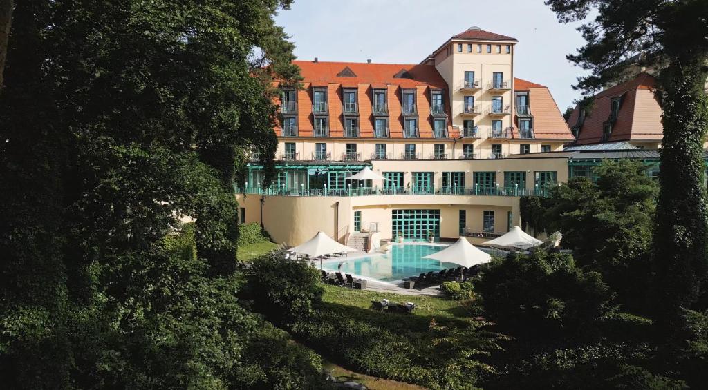 ein Hotel mit einem Swimmingpool vor einem Gebäude in der Unterkunft Precise Resort Scharmützelsee - Golf & SPA in Bad Saarow