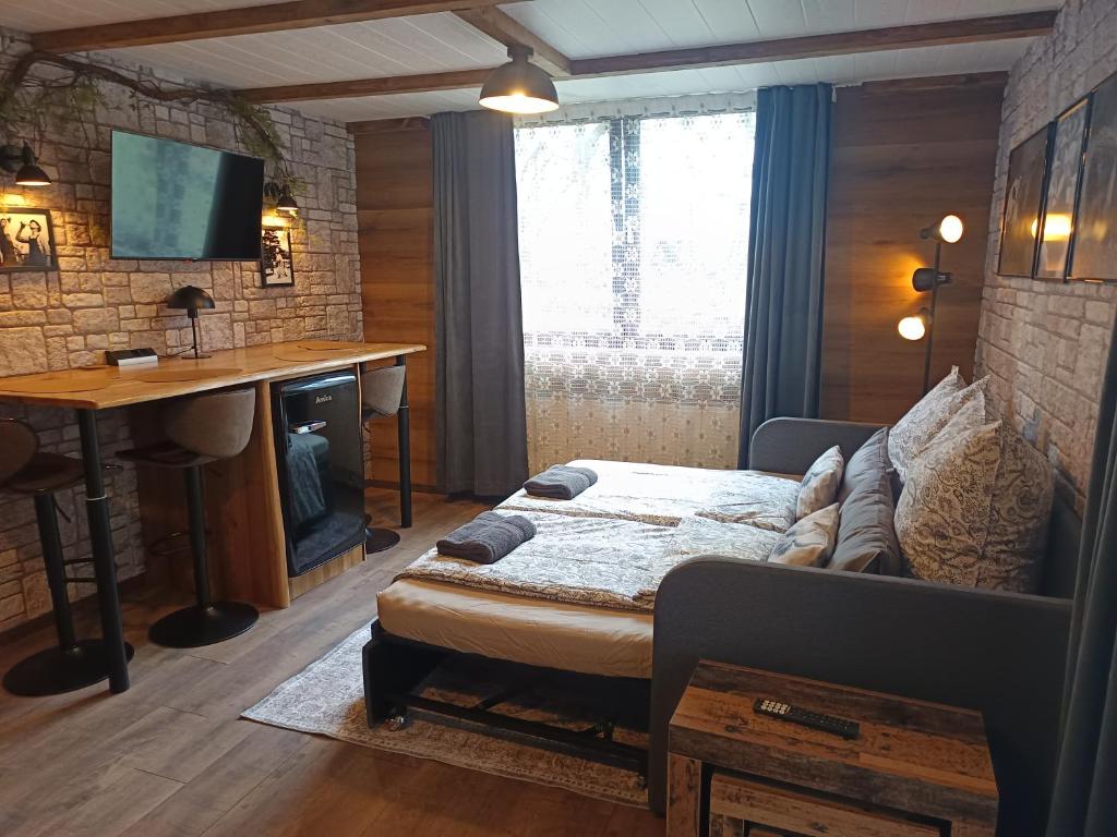 a bedroom with a bed and a desk and a table at FeWo Ottobeurens Schmuckstück Gemütlich-Stylische Wohnung - AMETHYST in Ottobeuren