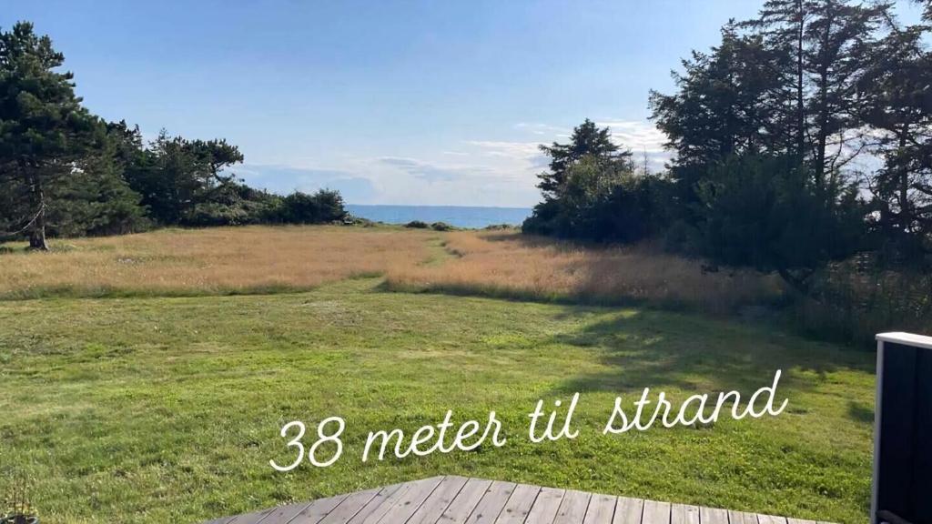a large field of grass with the words meter til stand at Summerhouse On The Beach And With Ocean View in Yderby