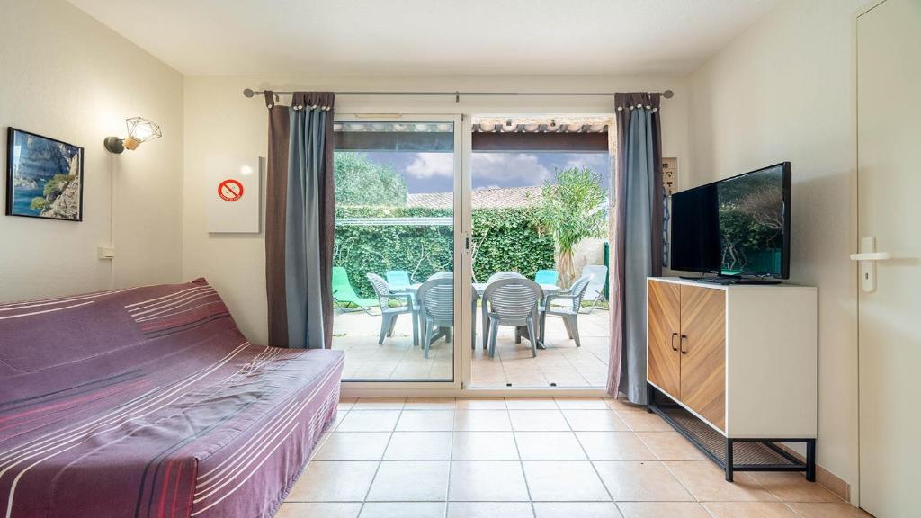 - une chambre avec un lit, une télévision et une terrasse dans l'établissement Samaria Village N08 - 2P4, à Agde